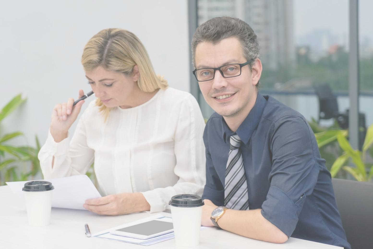 Business owner analyzing financial reports with calculator and charts on desk